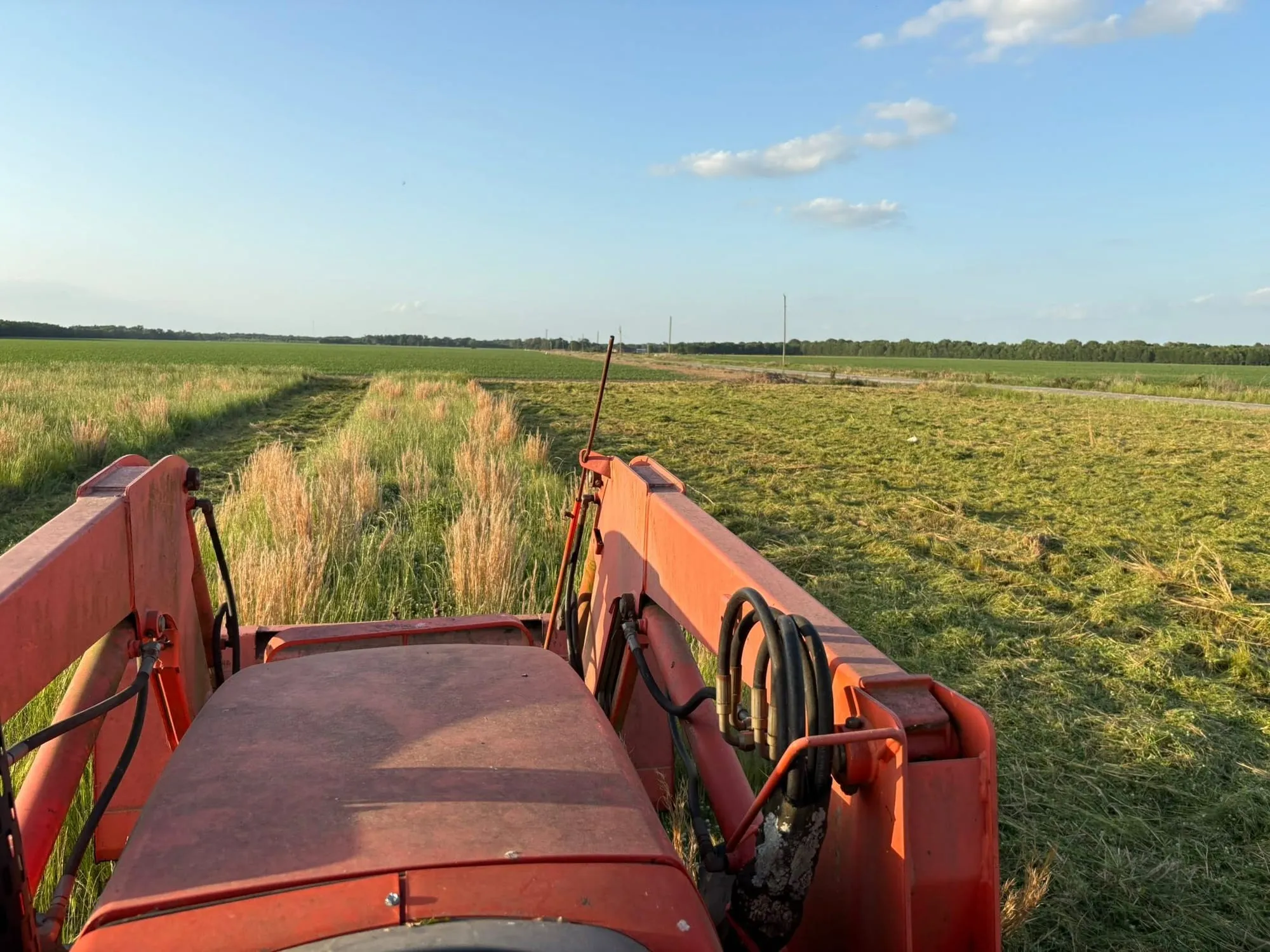Tractor mowing a large open hayfield in north Louisiana